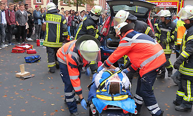 Das Bild zeigt die enge Zusammenarbeit zwischen mit den Rettungskräften der Feuerwehr und dem DRK mit der Erstversorgung des Unfallopfers